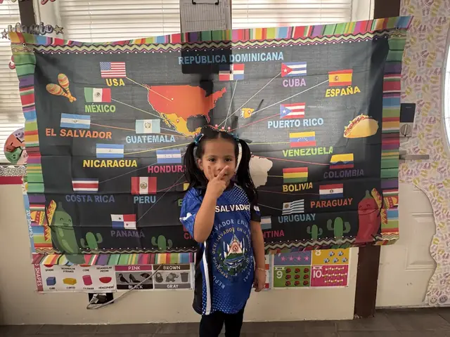 A girl in an El Salvador jersey makes a peace sign