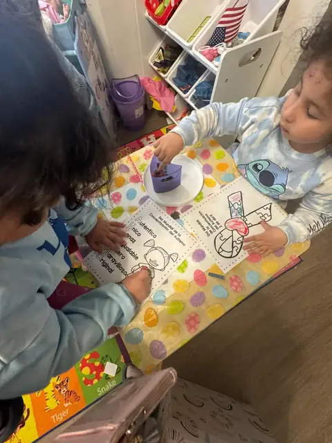 Two children color World Autism Awareness Day pages with puzzle-piece ribbons